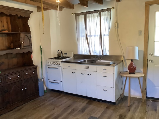 kitchen featuring white range with gas stovetop, dark hardwood / wood-style floors, white cabinetry, and sink