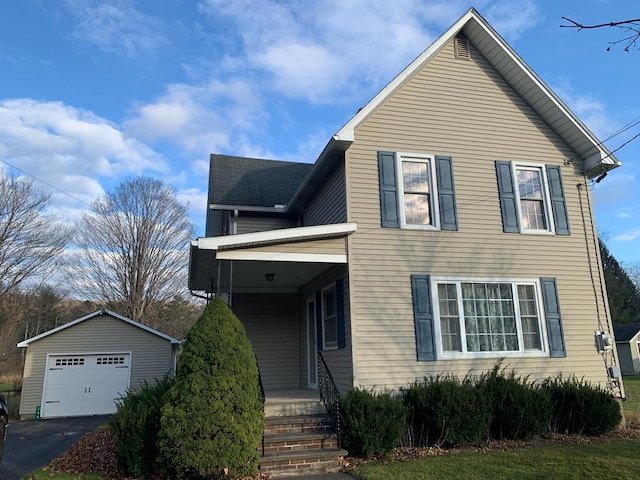 view of front facade with an outbuilding, a porch, and a garage