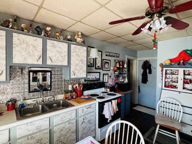 kitchen with ceiling fan, sink, a drop ceiling, and white electric range