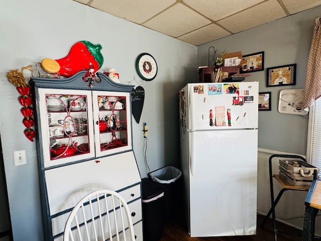 kitchen featuring a drop ceiling and white refrigerator