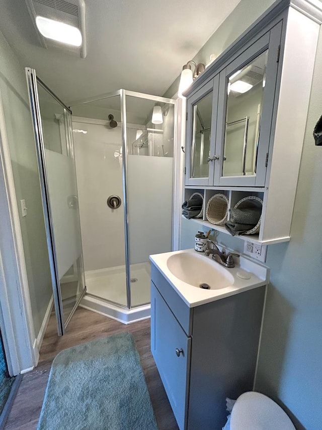 bathroom featuring hardwood / wood-style flooring, vanity, and a shower with shower door