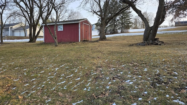 snowy yard featuring a storage shed