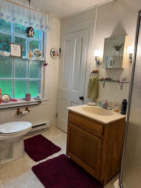 bathroom with tile patterned flooring, vanity, toilet, and a baseboard heating unit