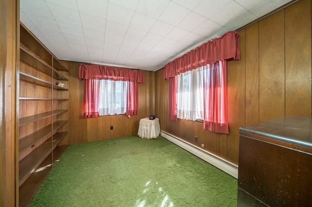 spare room with a baseboard radiator and wood walls