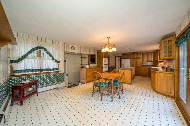 dining area featuring an inviting chandelier and a baseboard heating unit