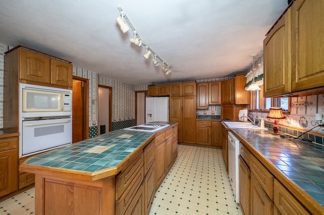 kitchen with tile countertops, sink, a kitchen island, and white appliances