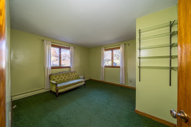 unfurnished room with dark carpet, a wealth of natural light, and a baseboard heating unit