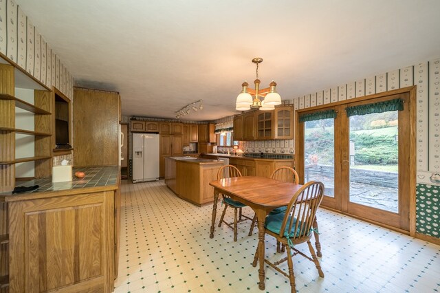 dining area with rail lighting and a chandelier