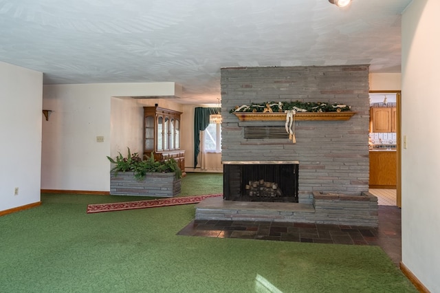 unfurnished living room featuring dark carpet, a textured ceiling, and a stone fireplace