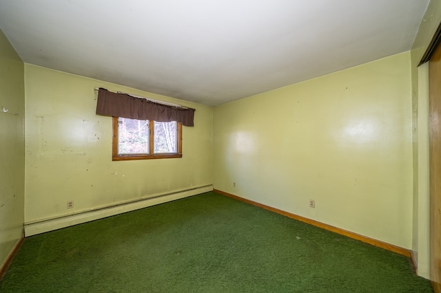 spare room featuring dark colored carpet and a baseboard heating unit