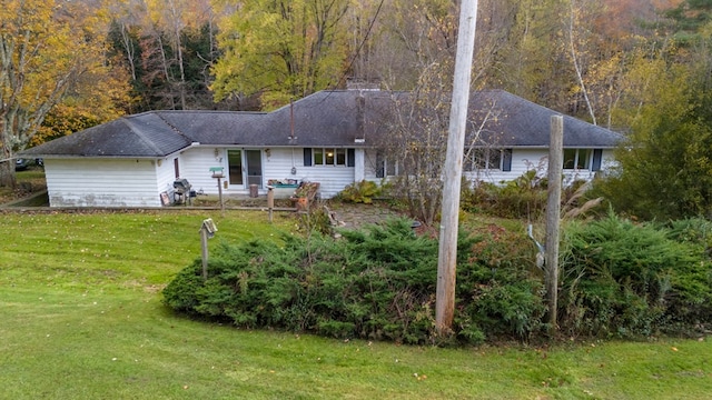 rear view of house featuring a lawn