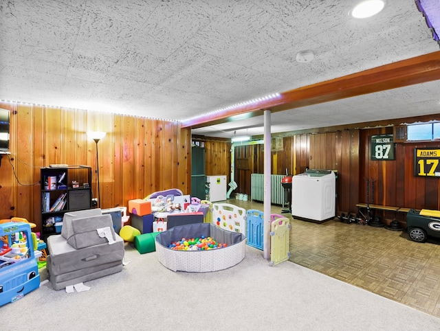 playroom with washer / clothes dryer, carpet flooring, and wood walls