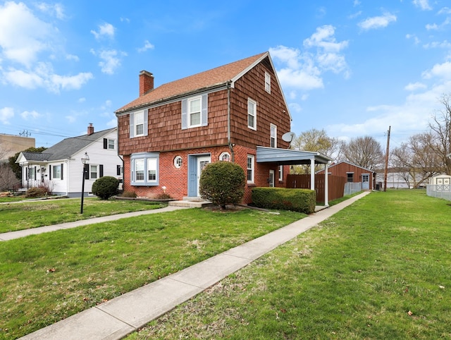colonial inspired home with roof with shingles, a chimney, a front lawn, and brick siding