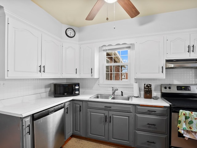 kitchen with gray cabinets, appliances with stainless steel finishes, a sink, white cabinets, and under cabinet range hood