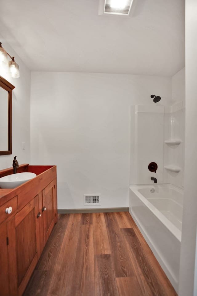 bathroom featuring wood-type flooring, shower / bath combination, and vanity