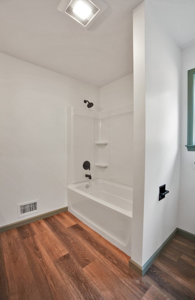 bathroom featuring hardwood / wood-style flooring and bathtub / shower combination