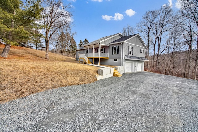 view of side of home with a garage and covered porch