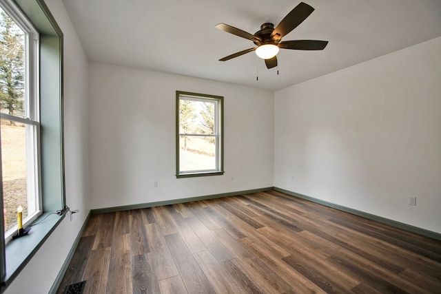 spare room with dark wood-type flooring and ceiling fan