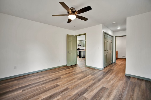 unfurnished bedroom featuring hardwood / wood-style flooring and ceiling fan