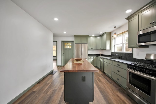 kitchen with dark wood-type flooring, wood counters, decorative light fixtures, a center island, and appliances with stainless steel finishes