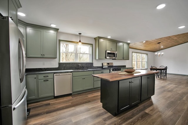 kitchen with sink, green cabinets, stainless steel appliances, a healthy amount of sunlight, and decorative light fixtures