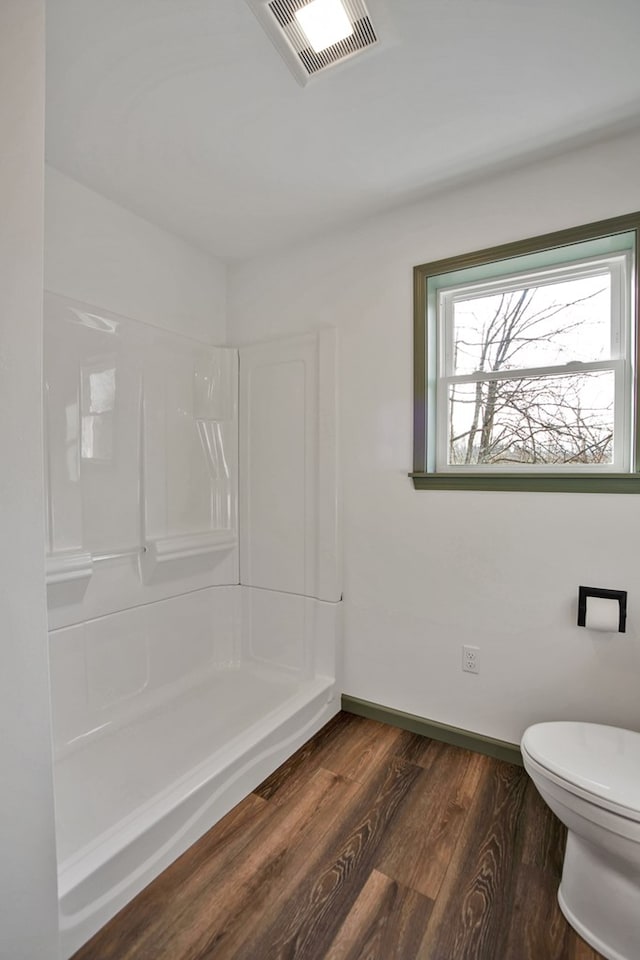 bathroom with toilet, hardwood / wood-style floors, and walk in shower