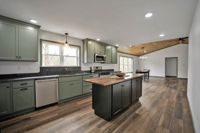 kitchen featuring green cabinetry, stainless steel appliances, sink, and hanging light fixtures