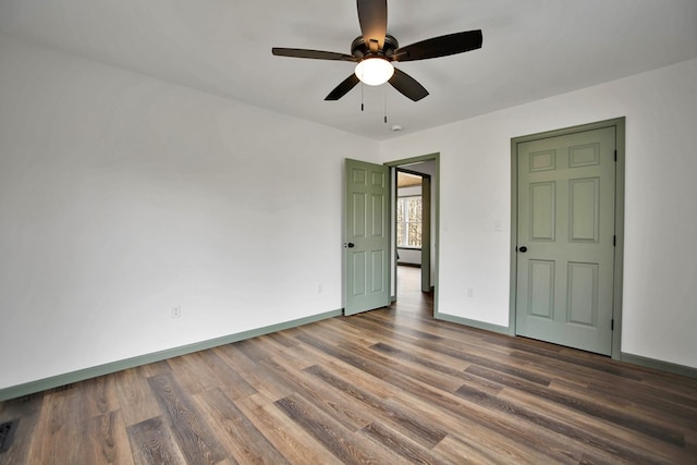 unfurnished bedroom featuring dark wood-type flooring and ceiling fan