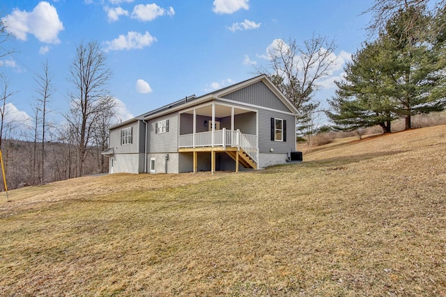 rear view of property featuring a yard and central air condition unit