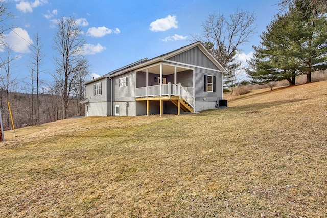 back of property featuring central AC unit, a lawn, and a porch