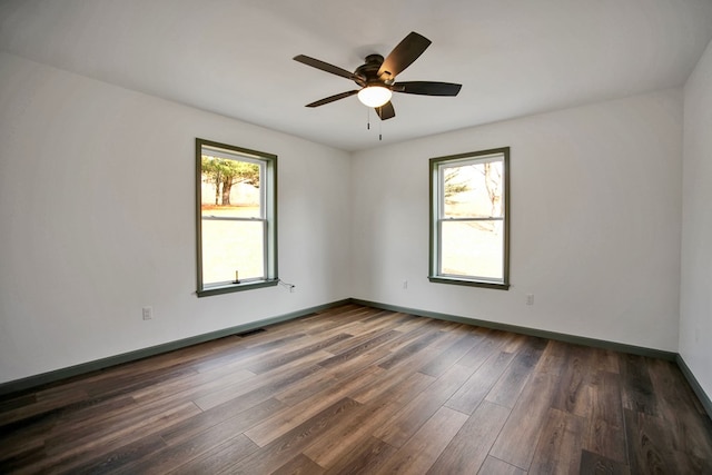 spare room featuring dark wood-type flooring and ceiling fan