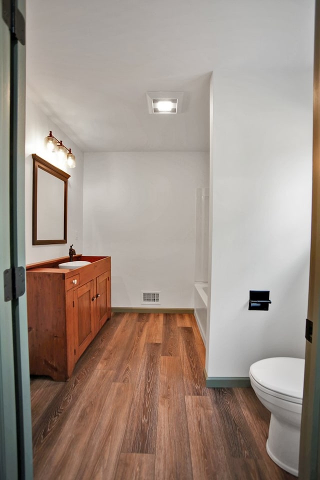 bathroom featuring vanity, hardwood / wood-style flooring, and toilet