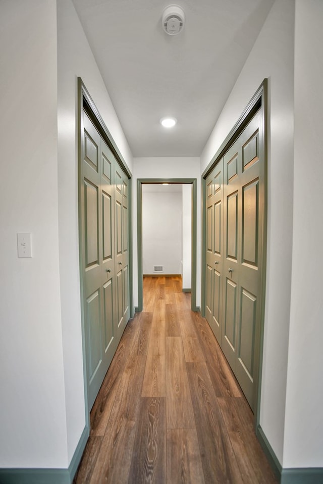 corridor with hardwood / wood-style floors