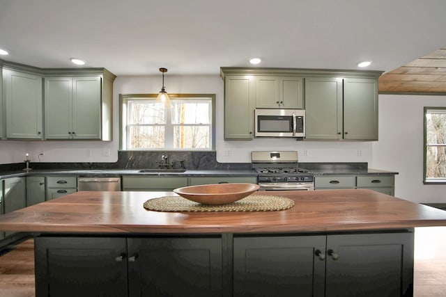 kitchen featuring green cabinetry, appliances with stainless steel finishes, sink, and wooden counters