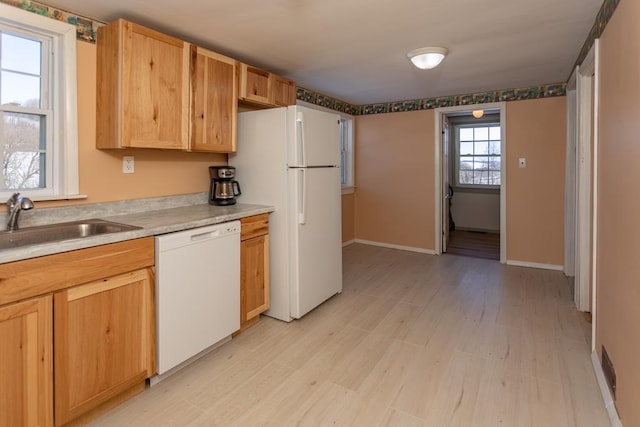 kitchen with white appliances, sink, light hardwood / wood-style floors, and light brown cabinets