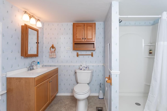 bathroom with toilet, vanity, and walk in shower