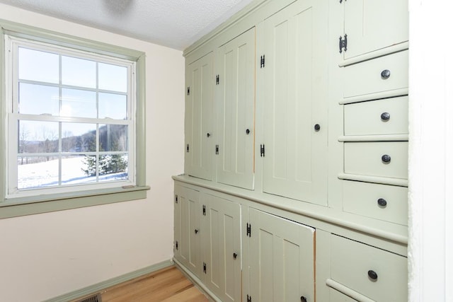 mudroom featuring light hardwood / wood-style flooring and a textured ceiling