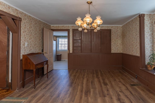 unfurnished room with ornamental molding, dark hardwood / wood-style floors, and an inviting chandelier