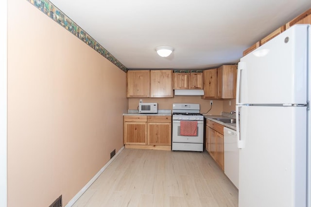 kitchen featuring sink, white appliances, and light wood-type flooring