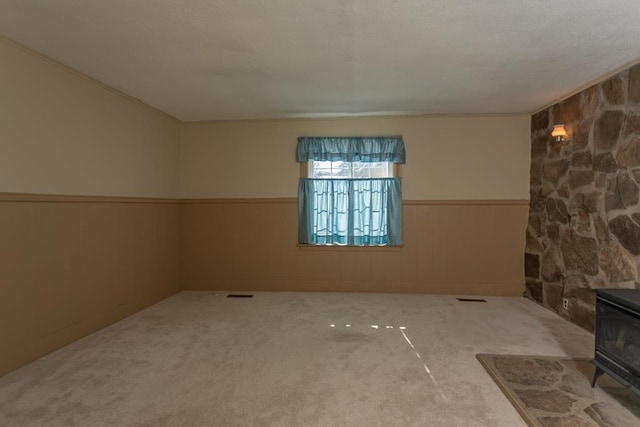 spare room with carpet floors and a wood stove