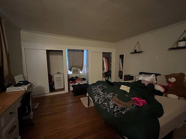 bedroom with cooling unit and wood finished floors