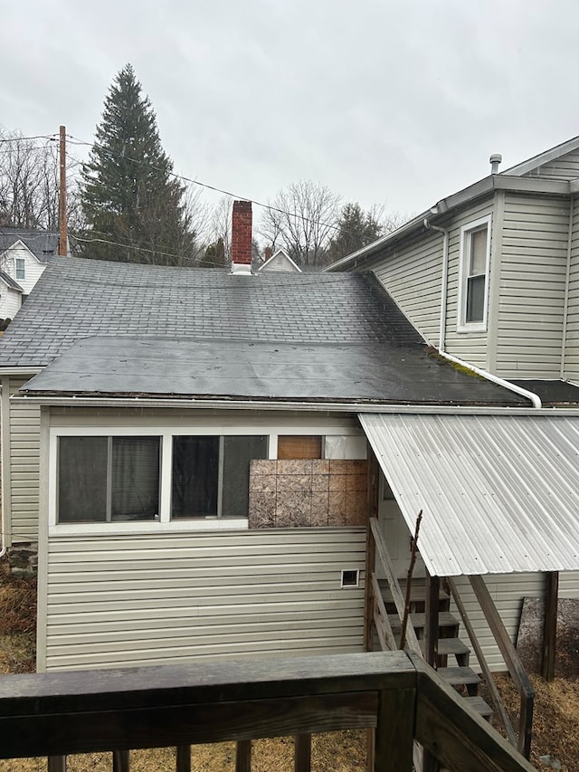 view of side of home featuring stairs and a chimney