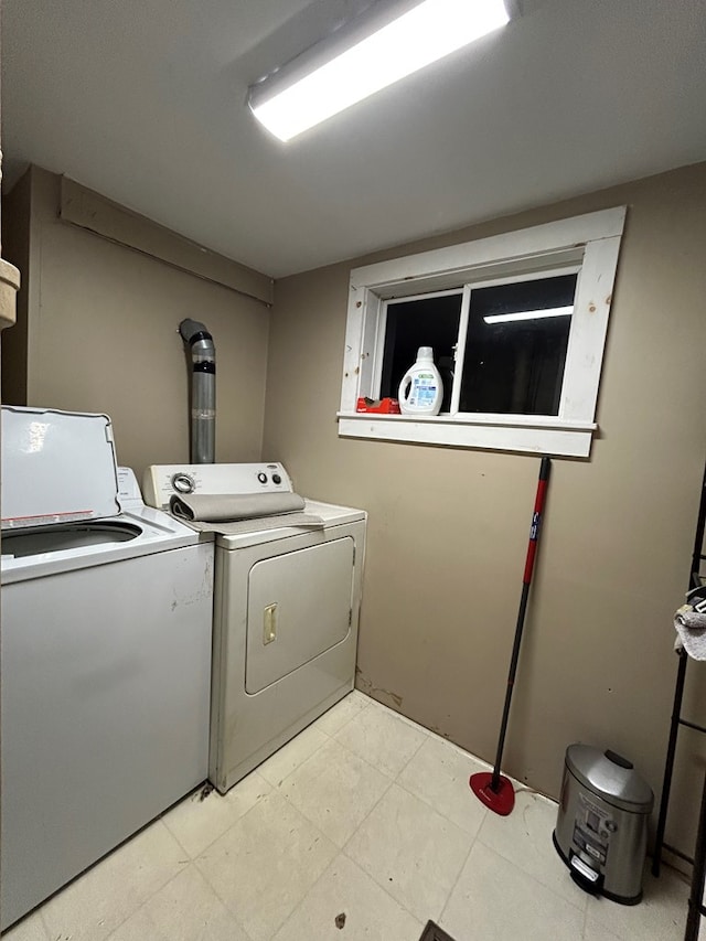 washroom featuring light floors, washing machine and dryer, and laundry area