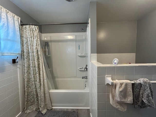 full bath featuring wood finished floors and shower / bath combo