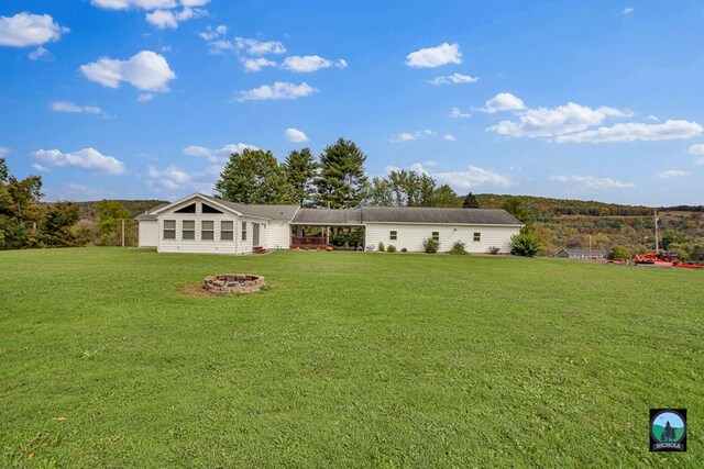 exterior space with a front lawn and an outdoor fire pit