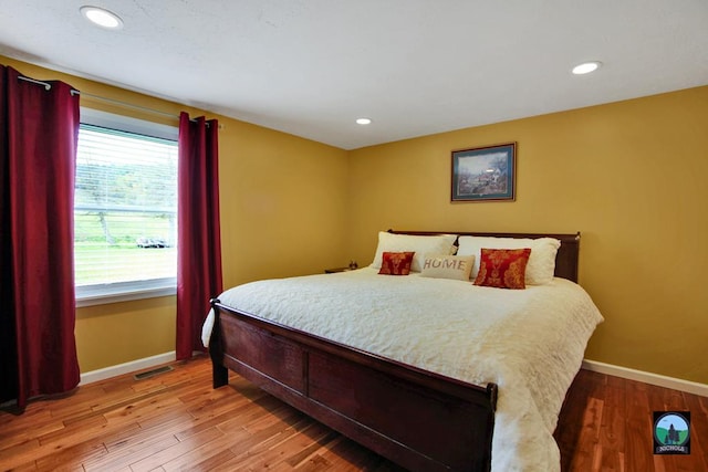 bedroom featuring hardwood / wood-style floors and multiple windows