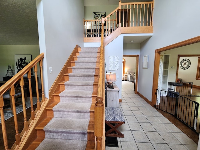 82 Cherry Tree Ln, Coudersport, PA 16915 - stairway featuring baseboards, tile patterned flooring, and a high ceiling