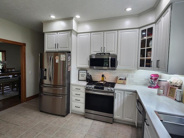 82 Cherry Tree Ln, Coudersport, PA 16915 - kitchen with appliances with stainless steel finishes, light countertops, backsplash, a textured ceiling, and light tile patterned floors