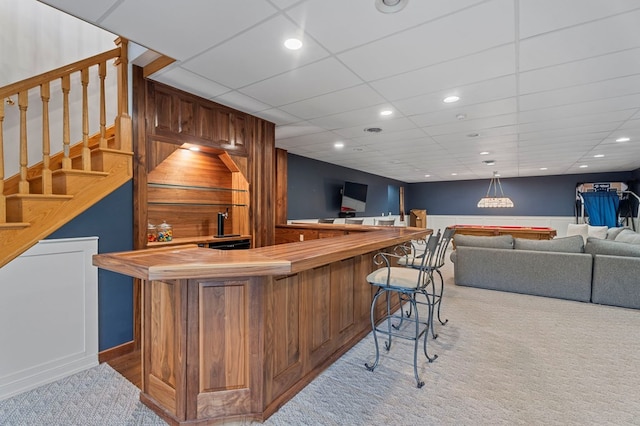 bar with carpet flooring, pendant lighting, and a drop ceiling