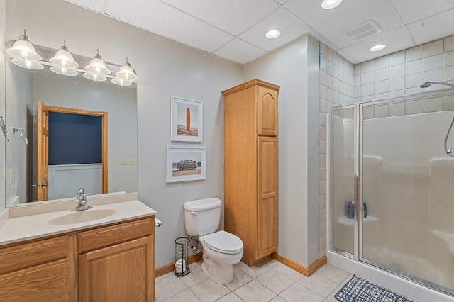 bathroom with tile patterned floors, vanity, toilet, and a shower with shower door